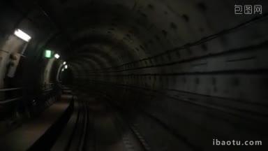 在黑暗的地下隧道中向前移动的慢动作，在昏暗的壁灯下沿着地铁铁路行进